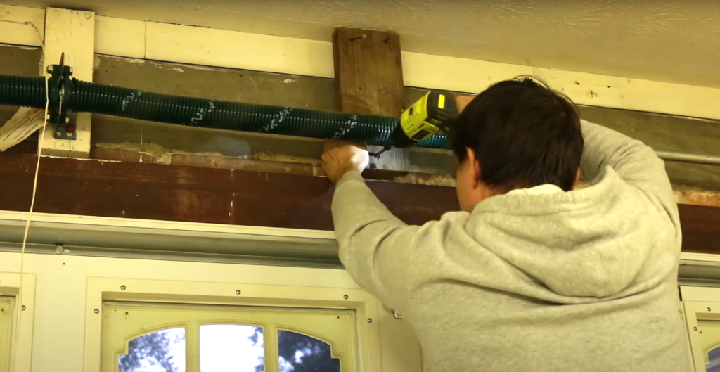 Close-up of a professional technician repairing a garage door spring with specialized tools, highlighting the garage door spring repair process in Punta Gorda, FL.